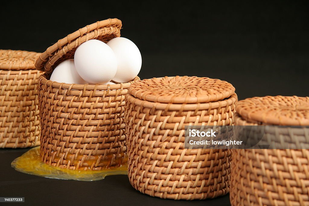 All Your Broken Eggs In One Basket Series of baskets with one containing eggs. The eggs appear to have broken since yolk is leaking out the bottom of the basket.  Don't Put All Your Eggs In One Basket Stock Photo