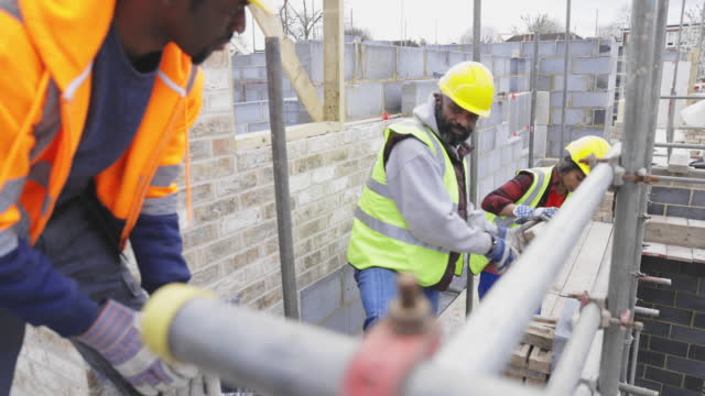 Construction workers stacking bricks at construction site