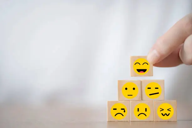 Hand Changing with smile emoticon icons  face on Wooden Cube , Costumer service concept