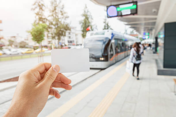 main d’un passager tenant une carte blanche vide pour le paiement sans contact et sans numéraire pour un système de transport urbain moderne dans la ville - car alarm photos et images de collection