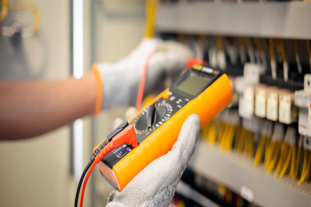 istock Electrician engineer uses a multimeter to test the electrical installation and power line current in an electrical system control cabinet. 1403779835