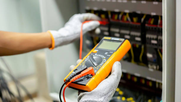 istock Electrician engineer uses a multimeter to test the electrical installation and power line current in an electrical system control cabinet. 1403779853