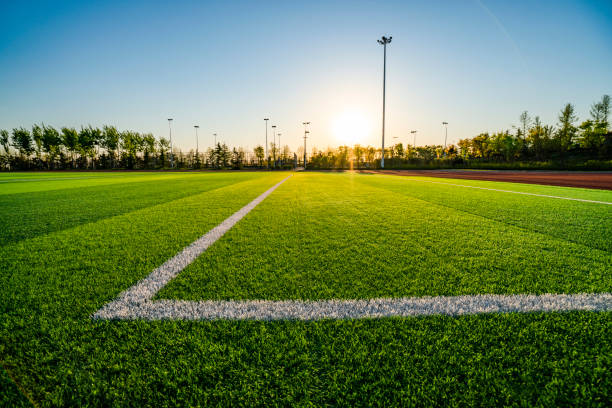 terrain de football au coucher du soleil - photo corner photos et images de collection