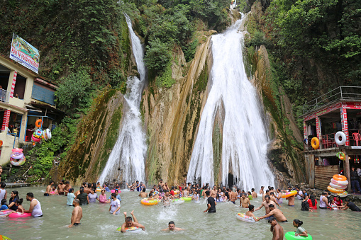 Mussoorie, Uttarakhand, India, June 18, 2022: People bathe at Kempty waterfall to beat the heat during summer season in Mussoorie. Tourists from across the country arrives here to celebrate weekend.