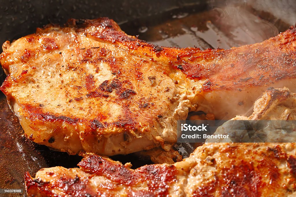 pork steak cooked pork steak cooked (real time shot you can see the smoke and the bubbles from oil) Cooked Stock Photo