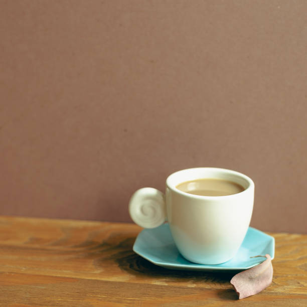 istock Cup of coffee on wooden table. brown wall background 1403782019