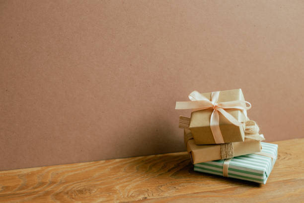 istock Stack of gift boxes on wooden table. brown wall background 1403782056