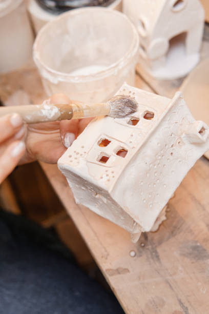 istock A master ceramist holds a clay product in his hands. Making a ceramic candle holder from clay. The process of coating the candlestick with glaze. 1403782155