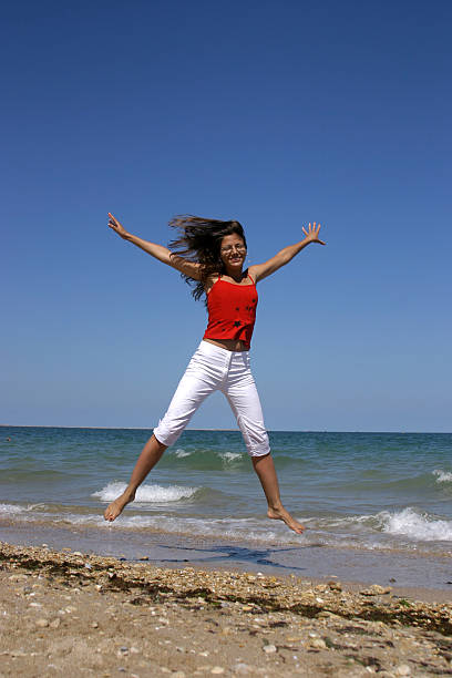 istock woman jumping on the beach 140378323