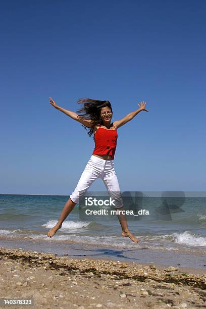 Mulher Saltar Na Praia - Fotografias de stock e mais imagens de Adulto - Adulto, Alegria, Ao Ar Livre