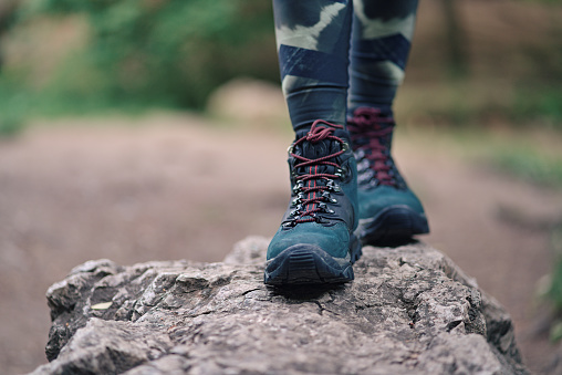 Woman walking on a rock in the forest . Physical exercise, healthy lifestyle and harmony concept