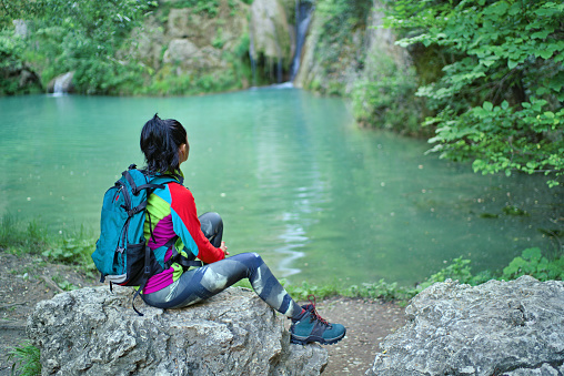 Rear view of a woman looking at a waterfall