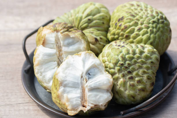 istock Custard apple and halved fruit on wooden background 1403788334
