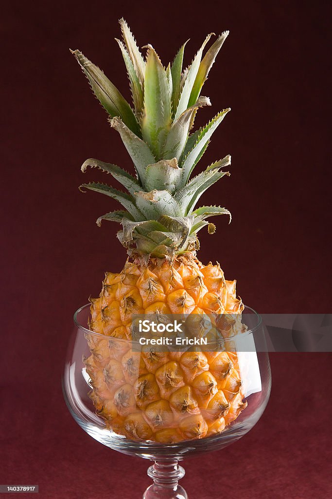 Pineapple in a glass A pineapple in a glass over a purple background Creativity Stock Photo