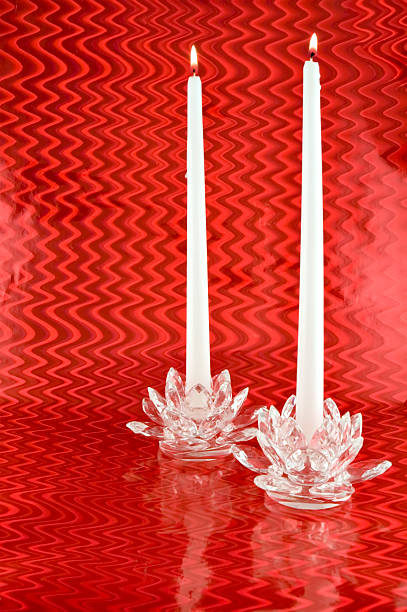 istock Two White Candles in Crystal Candleholders with Red Backgrounc 140379042