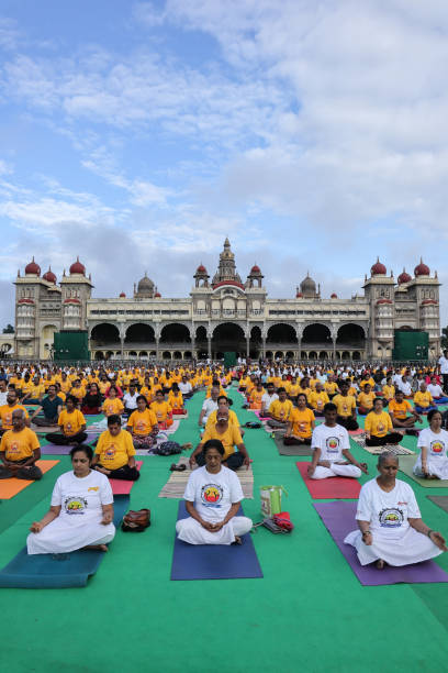 una imagen de retrato de personas de todos los ámbitos de la vida que participan en yoga sana para el día internacional del yoga en el palacio de mysore, india. - mysore fotografías e imágenes de stock