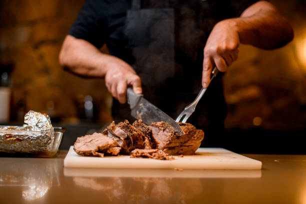 vista de la carne frita que el hombre corta en rodajas en tabla de cortar. - ready to cut fotografías e imágenes de stock