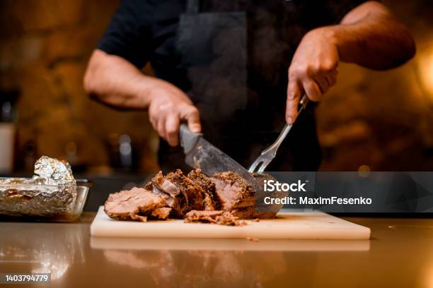View On Fried Meat Which Man Cuts To Slices On Cutting Board Stock Photo - Download Image Now
