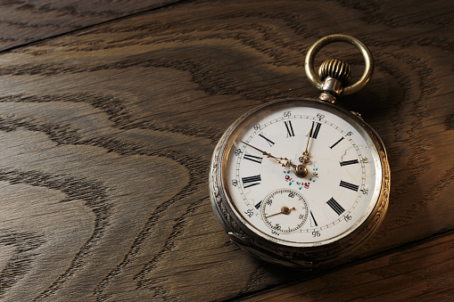 Old pocket mechanical watch isolated on black background. Pocket watch with antique accessory, vintage still life.