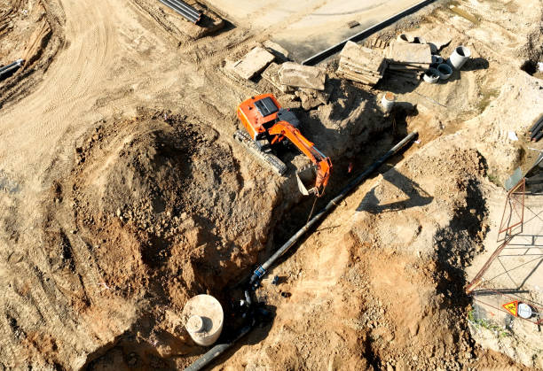 istock Sewage drainage system mounting at construction site. Excavator during laying sewer pipe and main systems. 1403794903