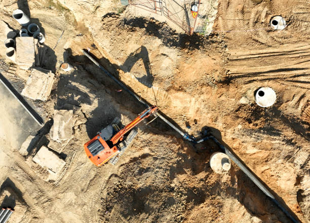 istock Sewage drainage system mounting at construction site. Excavator during laying sewer pipe and main systems. 1403794917