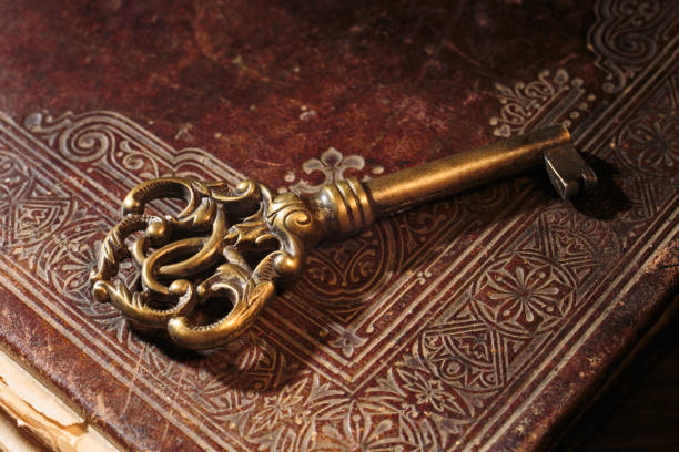 istock Antique key on ancient book. Bronze key with ornament. 1403795717