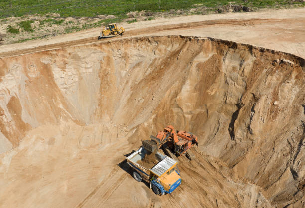 istock Excavator load sand into mining truck in opencast. Mining excavator in open pit during sand mining. Excavator on development sand pit. 1403795755