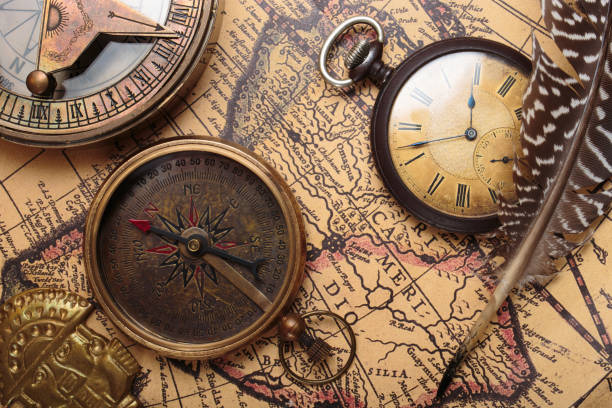 Maritime сompass, watch, quill pen on old map stock photo