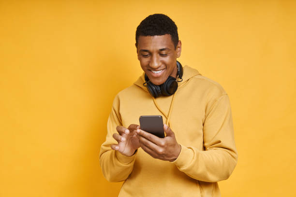 istock Handsome mixed race man with headphones using smart phone 1403798847