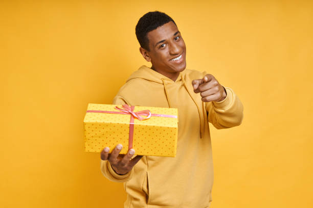 istock Handsome mixed race man giving a gift box and pointing 1403798872
