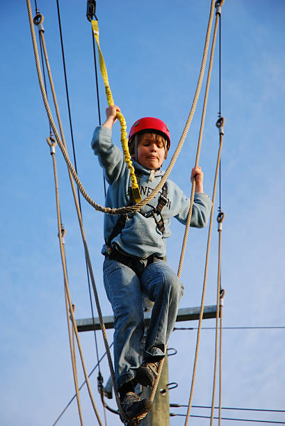 istock courageous boy standing on a steel wire high above 140379898