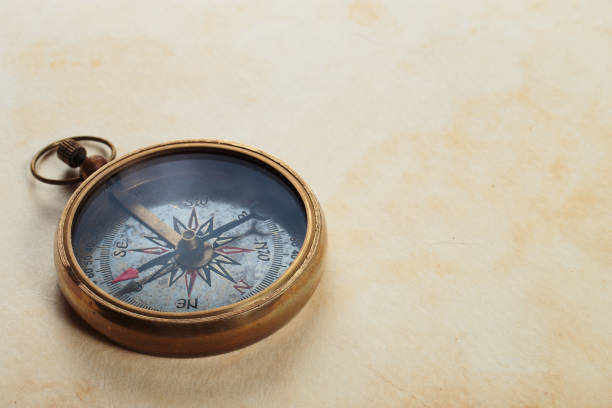istock Antique compass on old paper background. 1403798985