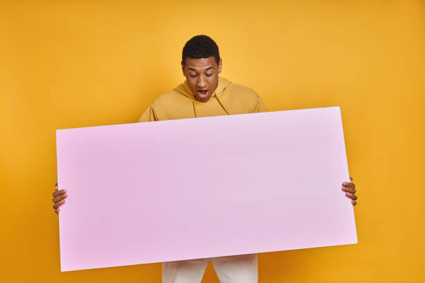 istock Shocked mixed race man carrying banner and looking at it 1403799092