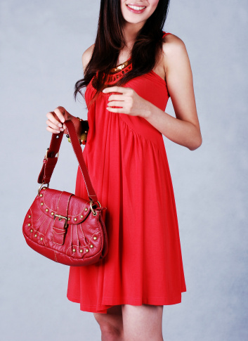 Closeup of women holding red handbag 