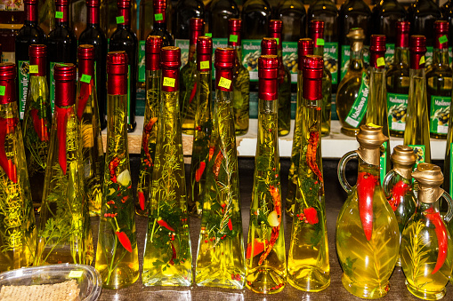 Makarska, Croatia - May 30, 2022: Olive oil bottles with pepper on the Makarska market - traditional Croatian souvenirs.