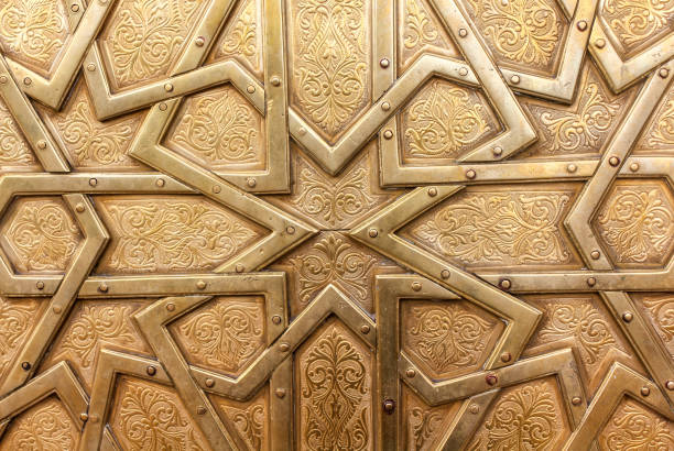 Sunlight filters through a traditional Moorish lattice window inside the Alhambra Palace in Granada, creating soft light beams and geometric patterns against a dark interior, symbolizing Islamic architectural design and spiritual atmosphere.