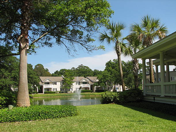 Scenic Living Beautifully landscaped apartment complex with palm trees and a fountain. Taken in St. Simons Island, GA.  saint simons island photos stock pictures, royalty-free photos & images