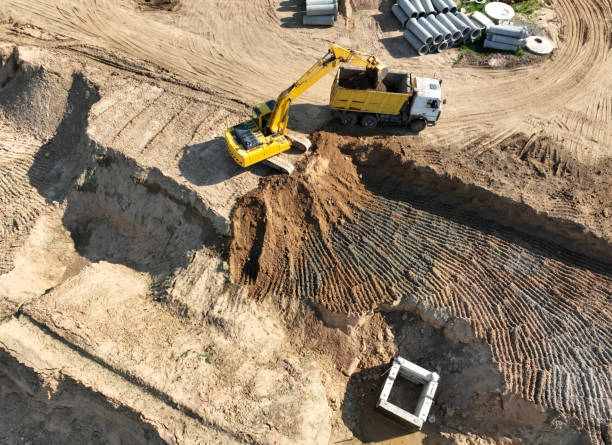 istock Excavator load sand in dump truck. Earthworks on construction site. Dig ground for sewer construction and sanitary sewer. Sewage drainage and concrete pipes 1403807994