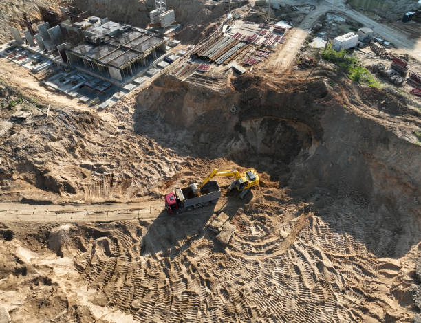 istock Excavator on earthworks at construction site. Backhoe on earthmoving. Excavator load ground in dump truck. 1403808557