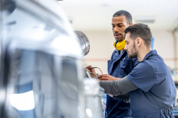 istock Aviation mechanics looking at multimeter measurements in helicopter hangar, medium shot 1403809589