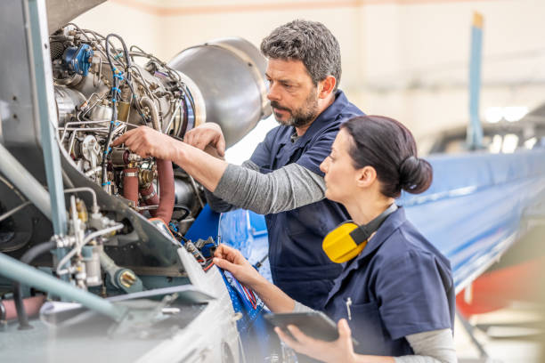 istock Aviation engineer teaching colleague repairing engine, side view 1403809648