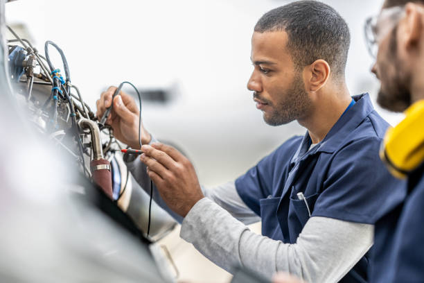 Aircraft engineers examining helicopter engine with multimeter, close up Aircraft engineers examining helicopter engine with multimeter, close up. Mechanics in uniforms working in hangar, side view repairperson occupation stock pictures, royalty-free photos & images