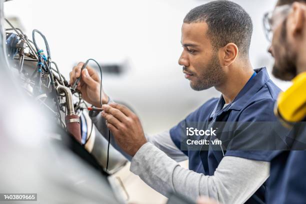 Aircraft Engineers Examining Helicopter Engine With Multimeter Close Up Stock Photo - Download Image Now