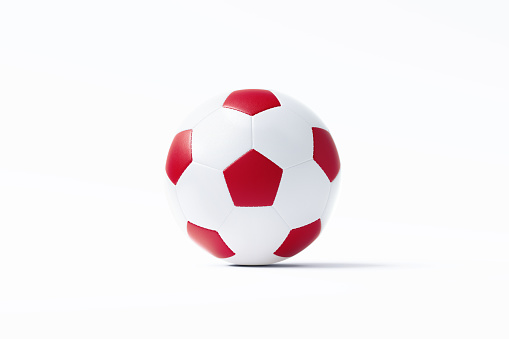 Red and white soccer ball sitting on white background. Horizontal composition with copy space. Clipping path is included.