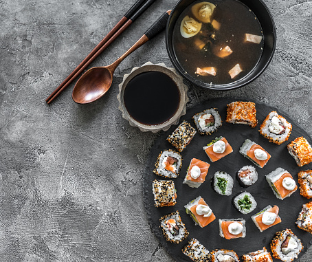 Sushi set in and miso soup on a concrete background with space for text