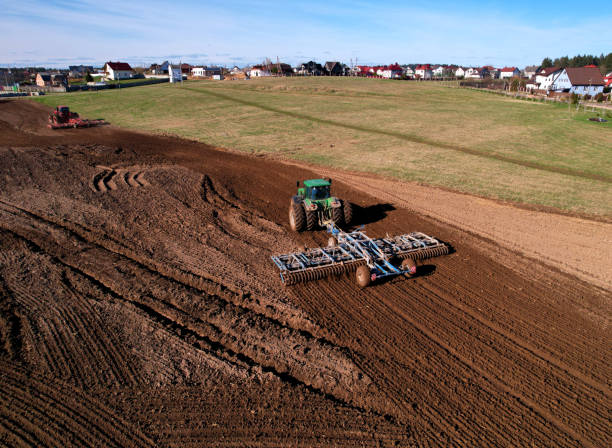 istock Tractor with cultivator plowing field. Tractor disk harrow on ploughing a soil. 1403810412