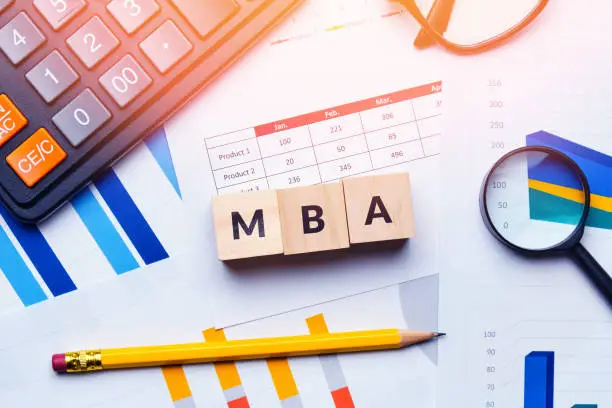 Concept MBA or master of business administration. Business acronym. Text on cubes and reporting charts