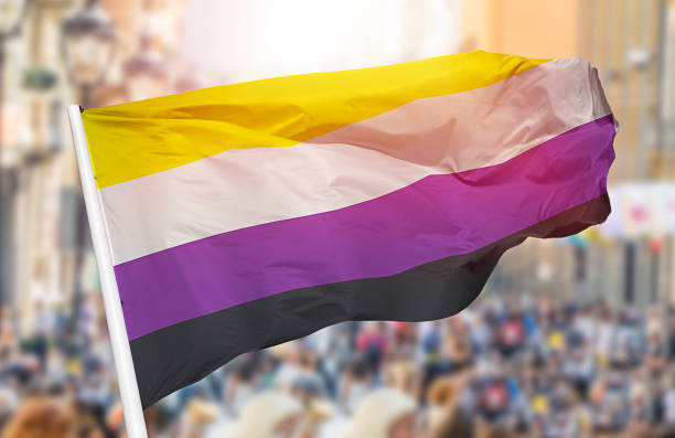 non binary pride flag blowing Shot of a non binary pride flag blowing in the wind at street non binary gender stock pictures, royalty-free photos & images