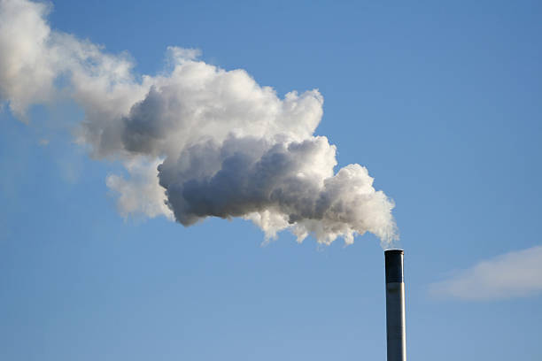 istock chimney billowing white smoke into blue sky 140381442