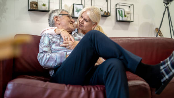 istock Woman embracing husband sitting on the couch 1403815216